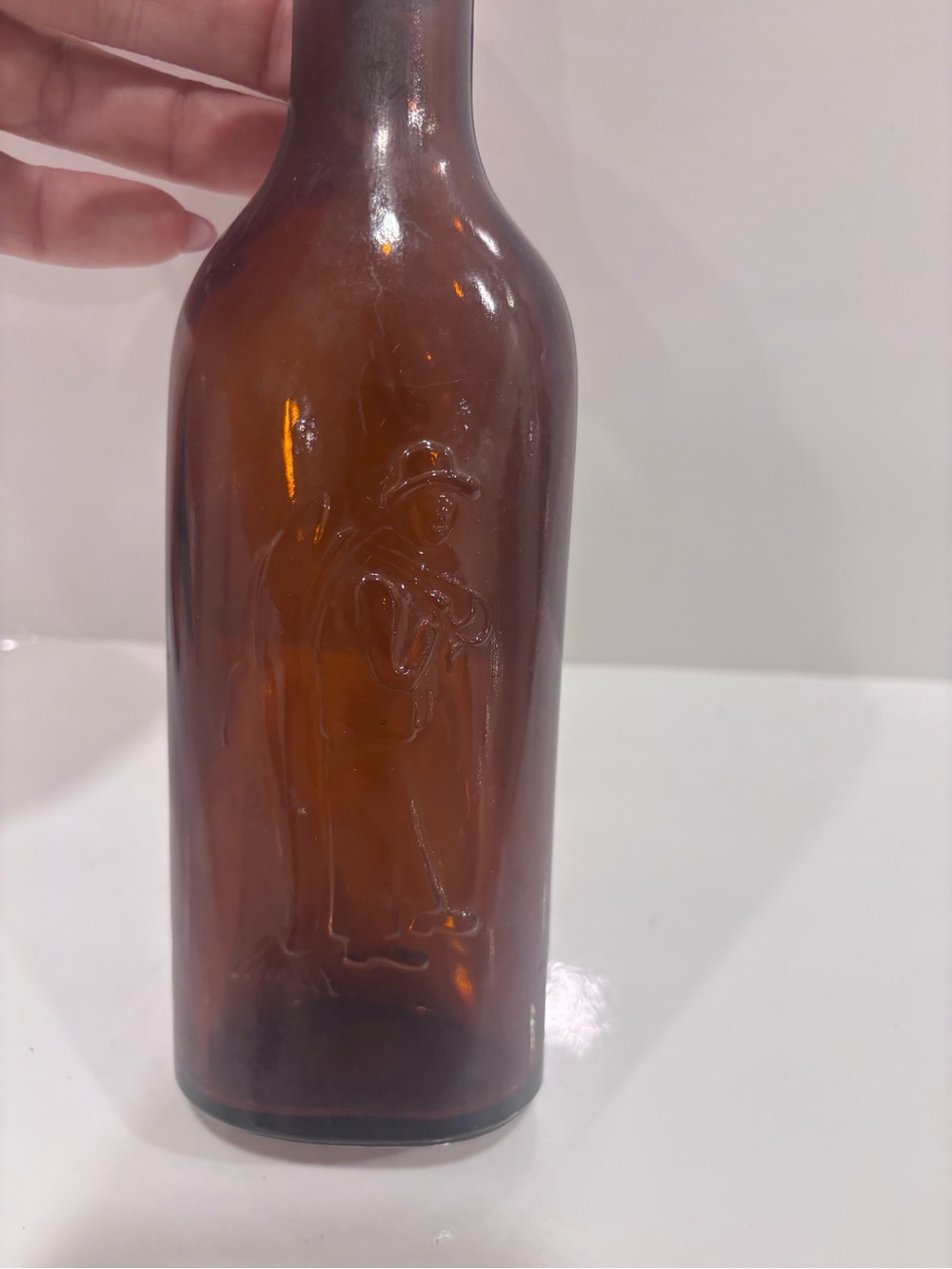 Vintage amber glass embossed doctor figure medicine bottle 1900-1925
